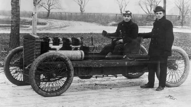 Henry Ford standing beside his famous racer 999 with Barney Oldfield at the tiller. Both Ford and Oldfield drove this four-cylinder, 80 horsepower racer to world speed records.