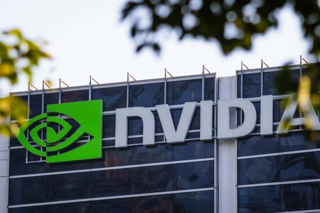 Primer plano del logotipo de Nvidia en un edificio de oficinas rodeado de algunas hojas en las ramas de los árboles