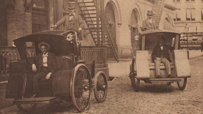Morris and Salom Electrobats pass in front of the Old Metropolitan Opera House on Manhattan's 39th Street in 1898. The Electrobats are electric battery-powered cars that served as early taxis in the city.