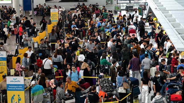 A photo of queues of people at an airport in Manila. 