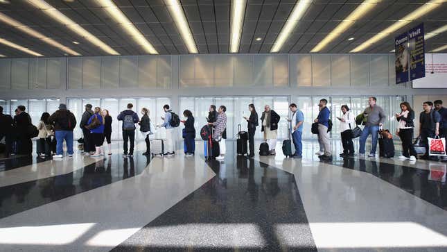 A queue of passengers line up at an airport 