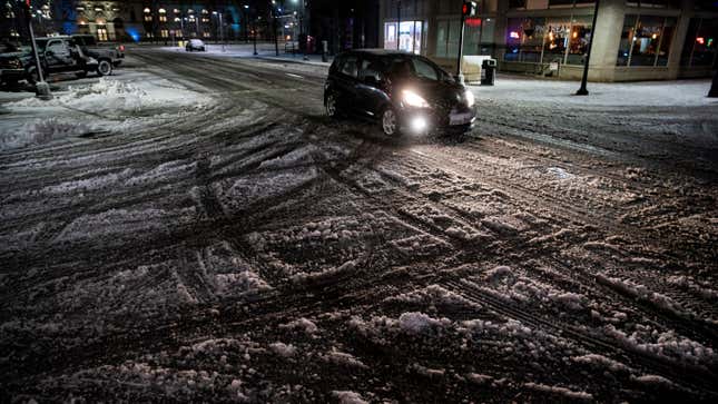 A vehicle drives through an intersection during a storm in Des Moines, Iowa, US, on Monday, Jan. 8, 2024. After a month of mild and relatively calm weather, the pattern in the US has shifted, sending a series of storms across the continent that will continue at least through mid-January. 