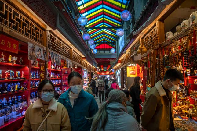 FILE - Visitors look at shops selling trinkets and souvenirs along a tourist shopping street in Beijing, Feb. 28, 2023. Asian economies are not doing as well as they could and growth in the region is forecast to slow to 4.5% this year from 5.1% in 2023, the World Bank said in a report released Monday, April 1, 2024.(AP Photo/Mark Schiefelbein, File)