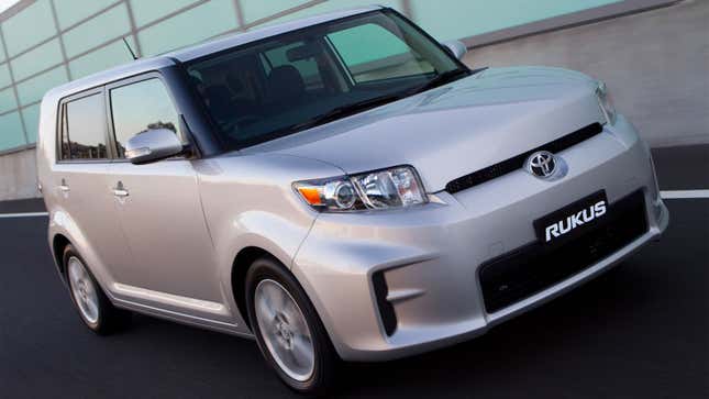 A photo of a silver Toyota Rukus hatchback driving on a road.