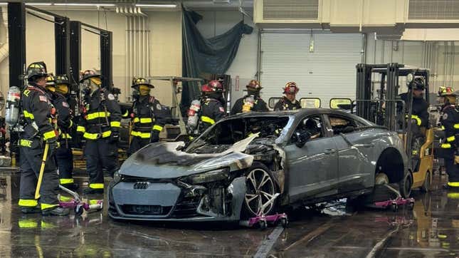 A photo of fire fighters gathered around an Audi E-Tron GT. 