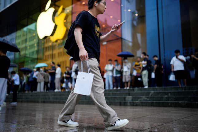 Man holding Apple bag outside an Apple store