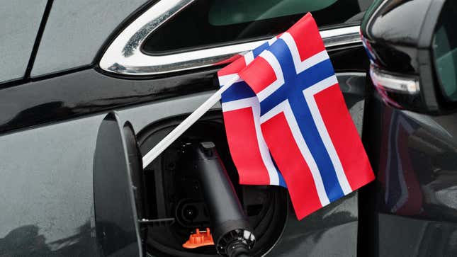 Concepto de automóvil ecológico con la bandera de Noruega. Enchufar una fuente de alimentación y cargar un automóvil moderno.