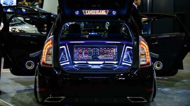 A photo of a car trunk with a large, illuminated stereo fitted into it. 