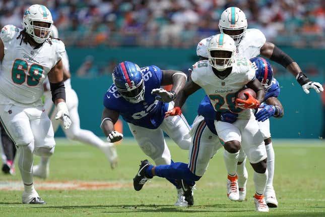 Miami Dolphins Running Back De'Von Achane (28) bricht für einen Gewinn aus, als New York Giants Safety Isaiah Simmons (19) in der ersten Hälfte eines NFL-Spiels im Hard Rock Stadium in Miami Gardens am 8. Oktober ins Spiel kommt. 2023.
