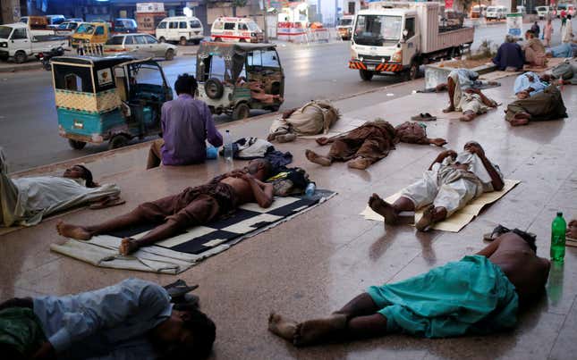 Residents sleep on a pavement to escape heat and frequent power outages in their homes.