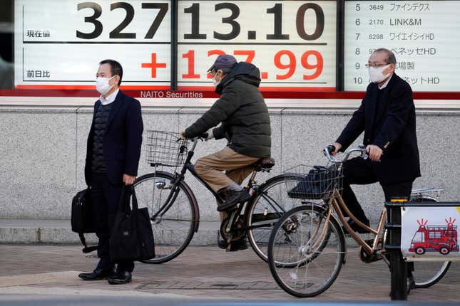 People wait for traffic signals to change in front of an electronic stock board showing Japan&#39;s Nikkei 225 index at a securities firm Tuesday, Nov. 14, 2023, in Tokyo. Asian shares were mostly higher Tuesday ahead of potentially market-moving developments, including a U.S.-China summit and data releases from the U.S., Japan and China. (AP Photo/Eugene Hoshiko)