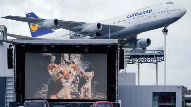 30 April 2020, Rhineland-Palatinate, Speyer: Cars are parked on a parking lot in front of a screen in the drive-in cinema of the Technik Museum Speyer. In the background a model of a Boeing 747 airplane can be seen as an exhibit.