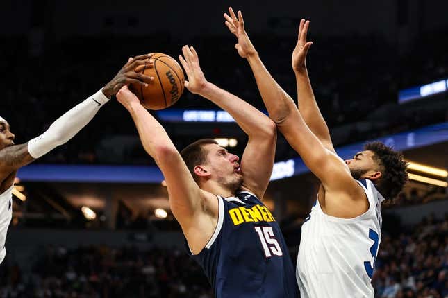 Nov 1, 2023; Minneapolis, Minnesota, USA; Minnesota Timberwolves forward Jaden McDaniels (3) blocks a shot by Denver Nuggets center Nikola Jokic (15) during the first half at Target Center.