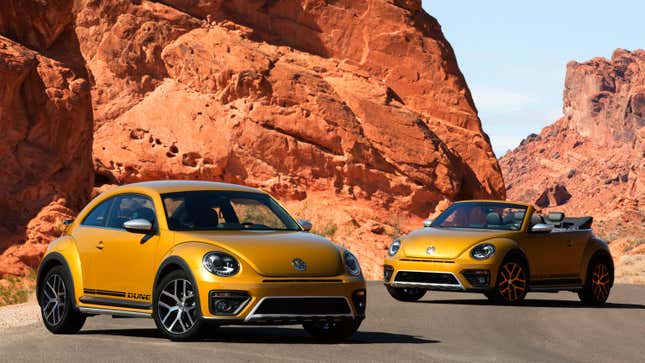 Deux VW Beetle Dunes dorées garées devant des formations rocheuses géantes