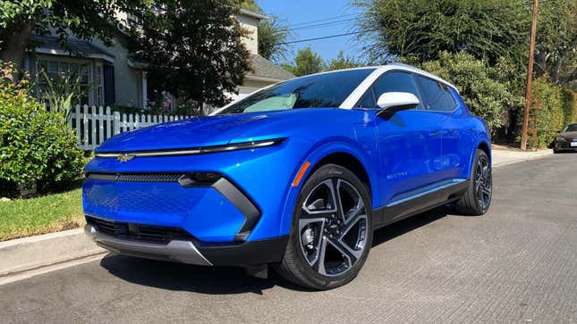 A bright blue equinox EV parked on the street from the front three quarters angle