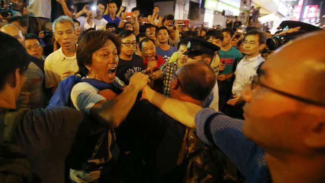 An anti-Occupy Central protester (left) argues with pro-democracy protesters on a main street at Hong Kong’s Mongkok neighborhood.