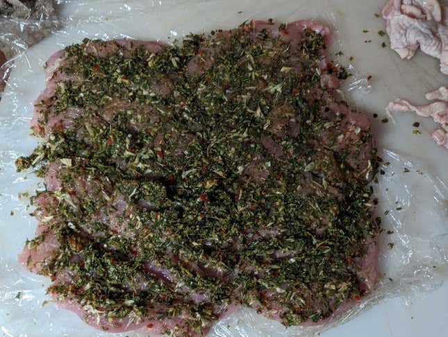 The herb mixture has been really well-rubbed into the cross-hatched surface of the turkey, with plastic under it so we can roll it easily. 