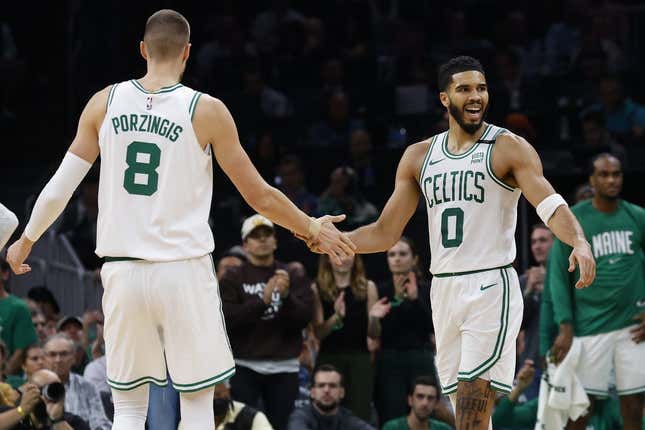 Oct 27, 2023; Boston, Massachusetts, USA; Boston Celtics forward Jayson Tatum (0) slaps hands with center Kristaps Porzingis (8) during the second quarter against the Miami Heat at TD Garden.