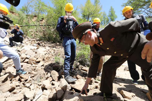 A North Korean official points a file of stones as he explains to journalists after the second tunnel of Punggye-ri nuclear test ground was blown up during the dismantlement process in Punggye-ri, North Hamgyong Province, North Korea May 24, 2018. Picture taken May 24, 2018.