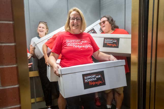 Corrin Day, from left, Cindy Maxwell-Ostdiek and Garrett Connely deliver petition signatures from Support Our Schools Nebraska to the Nebraska Secretary of State, Wednesday, Aug. 30, 2023, in Lincoln, Neb. Organizers of an effort to have Nebraska voters weigh in on whether to use taxpayer money to pay for private school tuition scholarships said Wednesday they have more than enough signatures to put that question on the November 2024 ballot. (Justin Wan/Lincoln Journal Star via AP)