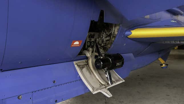 A photo of a ram air turbine on the side of a blue plane.