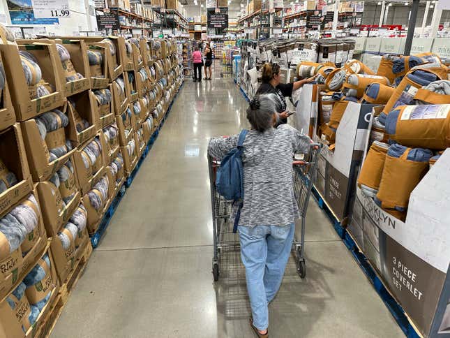 File - Shoppers look over blankets on sale in a Costco warehouse on Aug. 24, 2023, in Sheridan, Colo. On Thursday, the Commerce Department issues its first of three estimates of how the U.S. economy performed in the third quarter of 2023. (AP Photo/David Zalubowski, File)