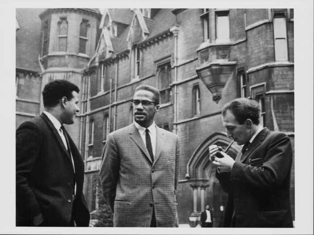 Malcolm X talking to two teachers during a visit, December 2nd 1964.