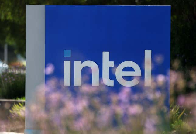 Intel sign partly covered by blurred purple flowers in the foreground