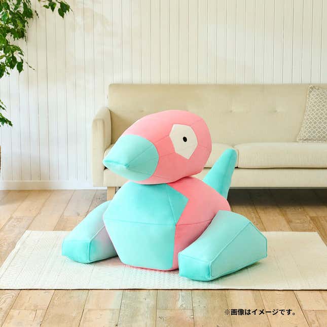 Una persona mira hacia abajo al peluche de Porygon.