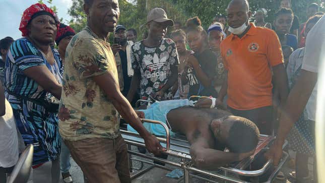 People transport an injured person after rescuing him from a house that collapse after an earthquake in Jeremie, Haiti, Tuesday, June 6, 2023.