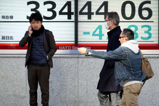 People walk in front of an electronic stock board showing Japan&#39;s Nikkei 225 index at a securities firm Friday, Dec. 1, 2023, in Tokyo. Asian shares declined on Friday even after Wall Street closed out its best month of the year with big gains in November. (AP Photo/Eugene Hoshiko)