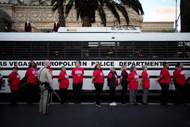 Members of the Culinary Workers Union are detained by Las Vegas police along the Strip, Wednesday, Oct. 25, 2023, in Las Vegas. Thousands of hotel workers fighting for new union contracts rallied Wednesday night on the Las Vegas Strip, where rush-hour traffic was disrupted when some members blocked the road before being detained by police. (AP Photo/John Locher)