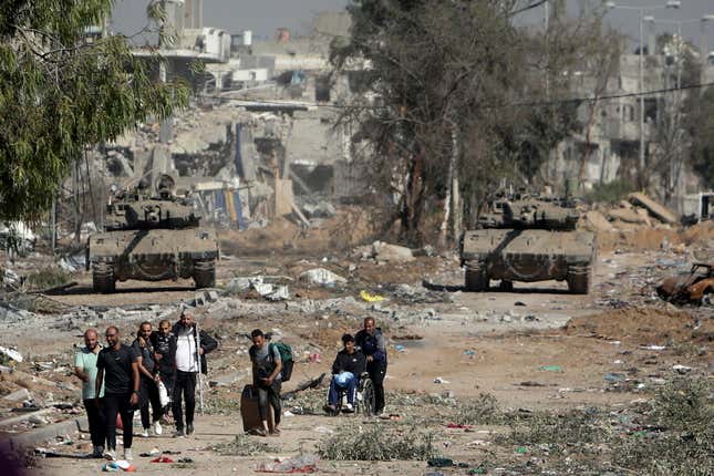 FILE - Palestinians flee from northern Gaza as Israeli tanks block the Salah al-Din road in the central Gaza Strip Friday, Nov. 24, 2023, as the four-day cease-fire in the Israel-Hamas war begins as part of an agreement that Qatar helped broker. The New York Times has frequently been at the forefront with journalists questioning their organization, including a debate surrounding another contentious issue, the war in Gaza. (AP Photo/Mohammed Dahman, File)