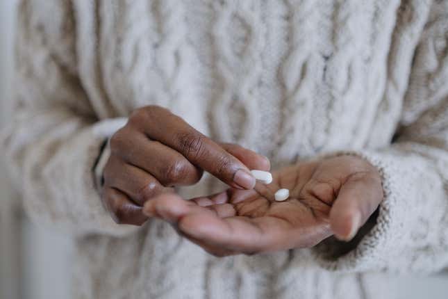 Close-up of woman holding pills. 