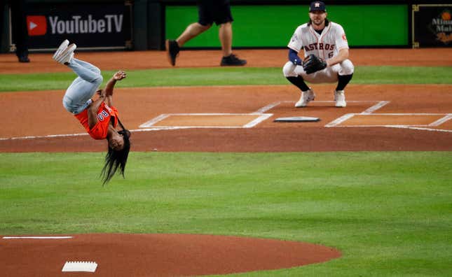 Simone Biles performs a flip while throwing out the ceremonial first pitch prior to Game 2 of the 2019 World Series on October 23, 2019 in Houston, Tx.