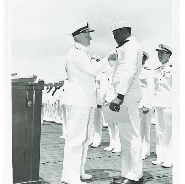 Doris Miller receives the Navy Cross from Adm. Chester W. Nimitz at an awards ceremony held on the flight deck of the USS Enterprise at Pearl Harbor. 