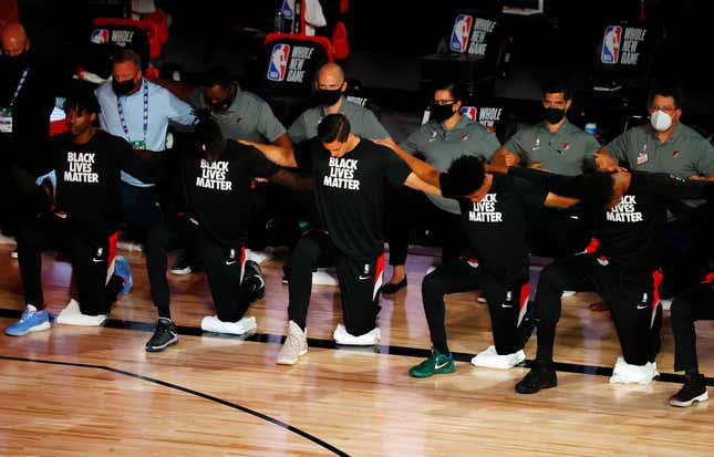  Players, coaches and staff kneel during the national anthem before the game between the Houston Rockets and the Portland Trail Blazers at The Arena at ESPN Wide World Of Sports Complex on August 04, 2020 in Lake Buena Vista, Florida.