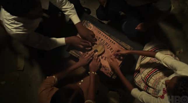 Four youngsters play with a Ouija board in Episode 3 of ‘Lovecraft Country.’