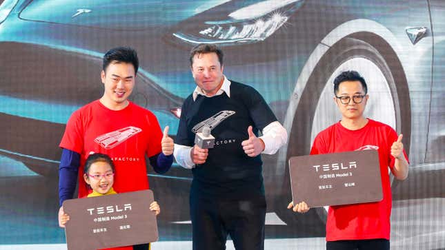 Elon Musk poses for photos with buyers during the Tesla China-made Model 3 Delivery Ceremony in Shanghai.