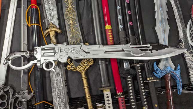 A gunblade from Final Fantasy XIV lays on top of other swords.