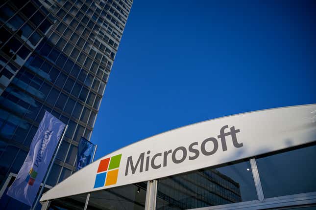 upward view of Microsoft logo on a building against blue sky