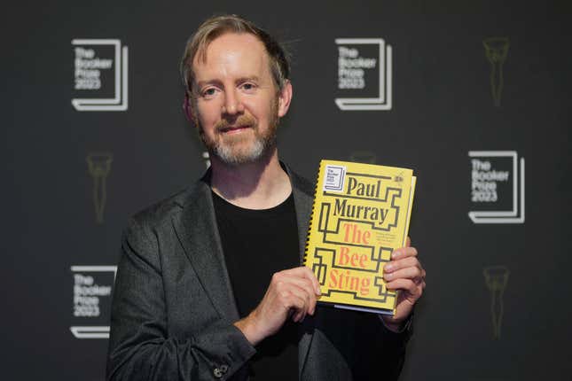 FILE - Irish author Paul Murray poses with his book &quot;The Bee Sting&quot; during a photocall for the Booker Prize 2023, in London on Nov. 23, 2023. (AP Photo/Kin Cheung, File)