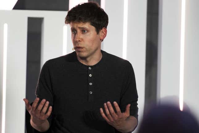 sam altman wearing a lav mic, head turned to his right, speaking with his palms turned up