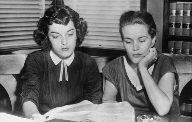 Carolyn Bryant und Juanita Milam (1927–2014), die Ehefrauen von Roy Bryant und John William Milam, die der Entführung und Ermordung von Emmett Till angeklagt sind, sitzen in der Kanzlei des Anwalts ihres Mannes gegenüber dem Gerichtsgebäude und lesen Zeitungsberichte über den Prozess im Gerichtsgebäude von Sumner in Sumner, Mississippi, September 1955. Der schwarze Teenager Emmett Till soll Carolyn Bryant nachgepfiffen haben. (