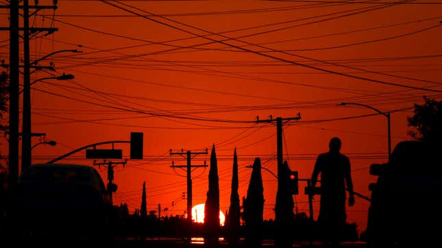 The sun sets behind power lines in Los Angeles, California on September 3, 2020.