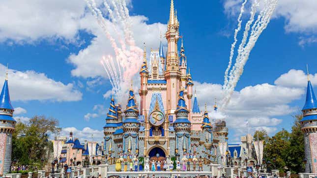 Disney World's Magic Kingdom castle is seen with fireworks and costumed characters in front.