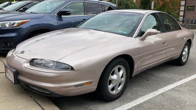 Un modelo base de Oldsmobile Aurora de 1998 en color champán metálico. Esta Aurora está equipada con el motor V8 de 4,0 litros y se ensambla en Orion, Michigan.  Esta Aurora está en perfecto estado, incluso 24 años después.