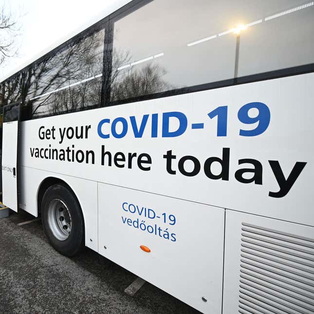 A photo of a Covid-19 vaccine sign on the side of a bus. 