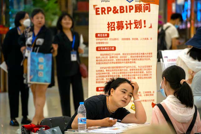 FILE - A recruiter talks with an applicant at a booth at a job fair at a shopping center in Beijing, on June 9, 2023. A record of more than one in five young Chinese are out of work, their career ambitions at least temporarily derailed by a depressed job market as the economy struggles to regain momentum after its long bout with COVID-19. (AP Photo/Mark Schiefelbein, File)