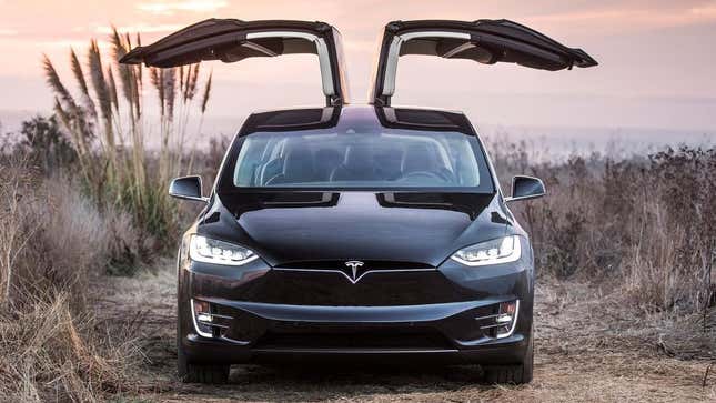 a black model X parked with its doors up 